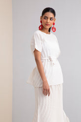 Woman in beige, pleated co-ord set, front view
